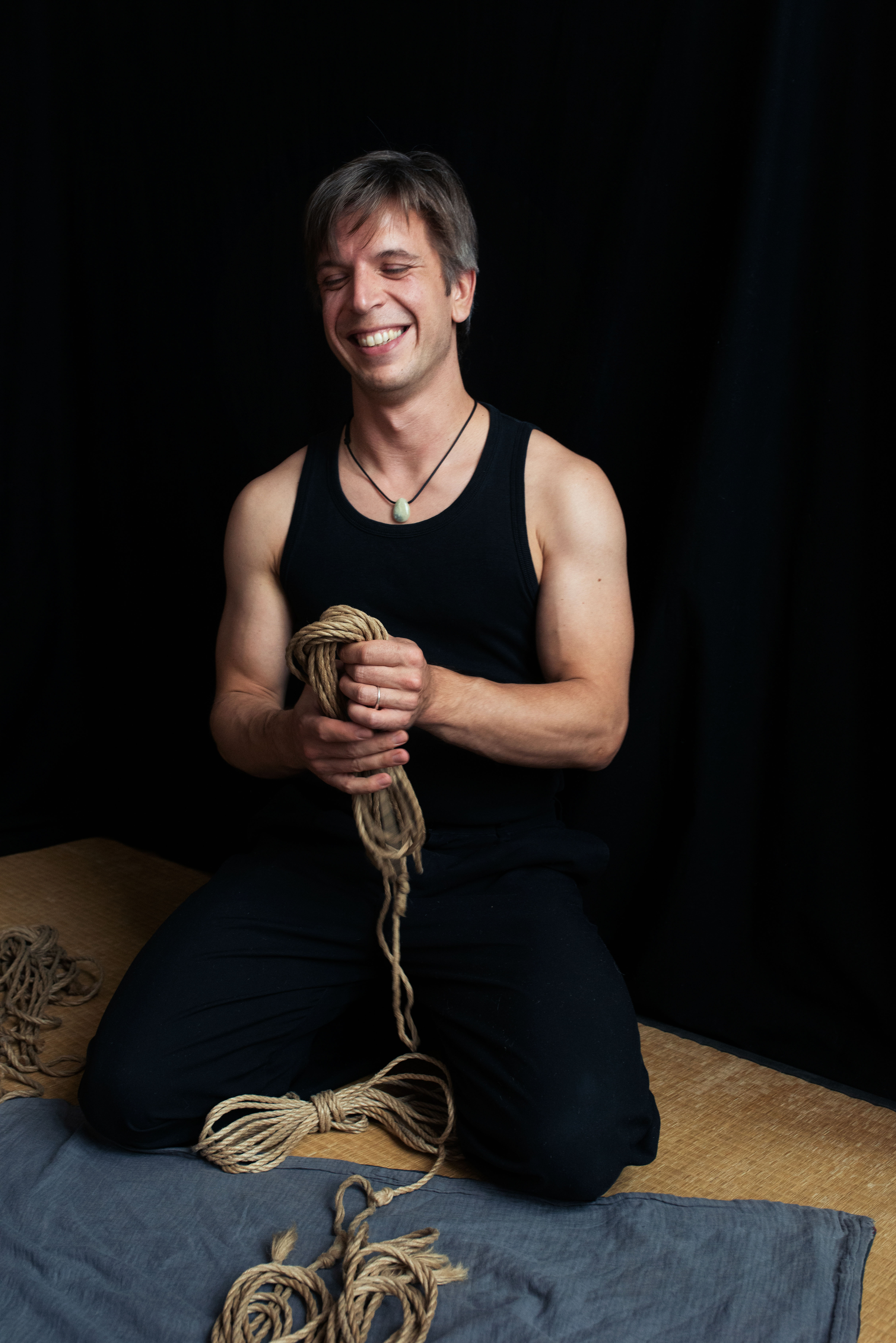 Portrait of Nick from Iris Red Horse holding shibari rope in a calm studio setting in Brussels. 